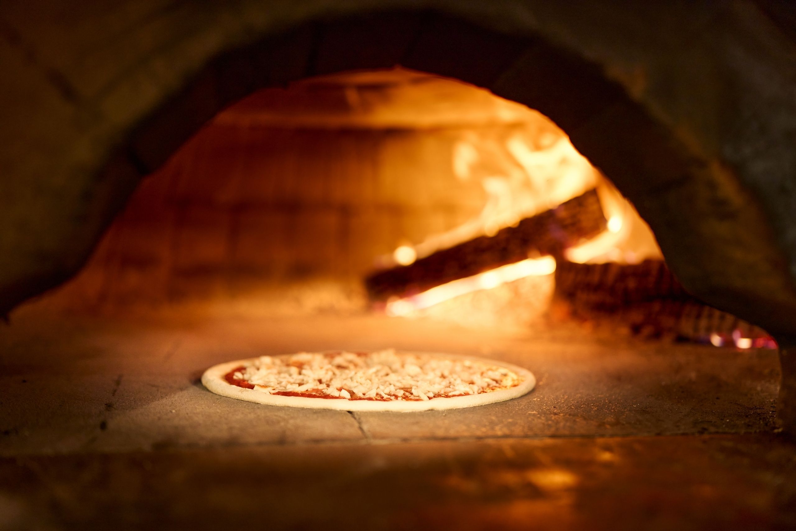 Cuisson d'une pizza au feu de bois au restaurant de Thônex